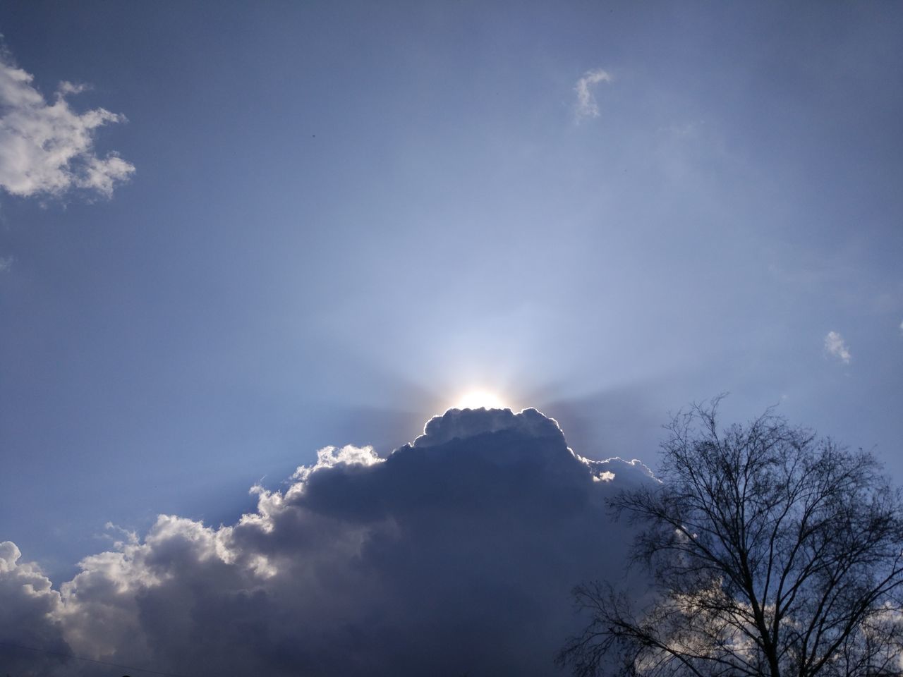 LOW ANGLE VIEW OF SUN STREAMING THROUGH CLOUDS