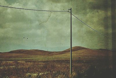 Scenic view of field against cloudy sky