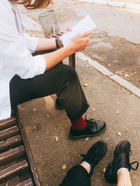 Low section of people sitting on bench