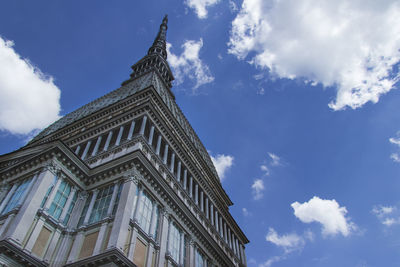 Low angle view of building against cloudy sky