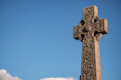 Low angle view of cross against clear blue sky