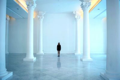 Woman standing amidst column in room