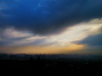 View of cityscape against cloudy sky