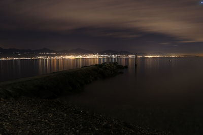 Pier over sea against sky at night