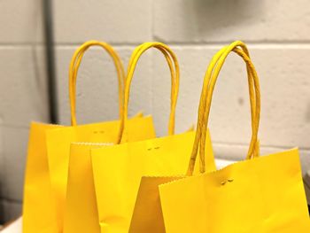 Close-up of yellow paper hanging against wall