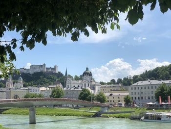 Arch bridge over river against buildings in city