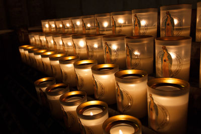 Close-up of illuminated candles in row