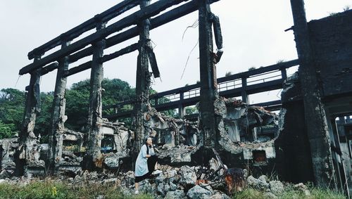 Woman standing by abandoned building