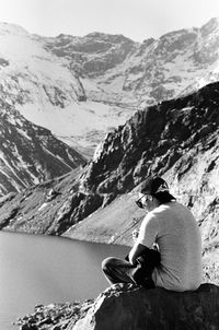 Rear view of woman sitting on mountain