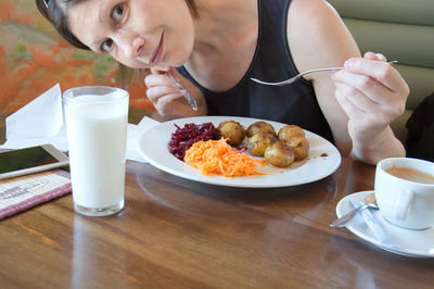 Portrait of woman having food at table