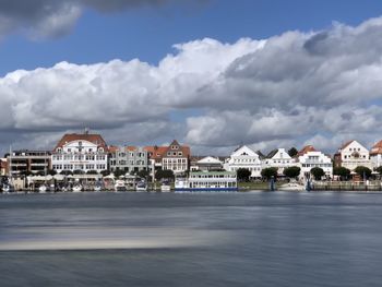 Buildings by sea against sky in city