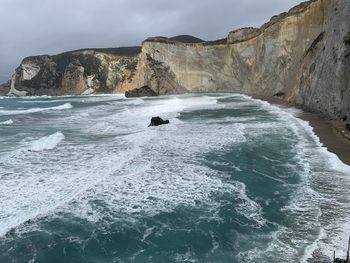 Scenic view of rocks in sea against sky