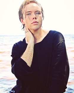 Portrait of young man standing at beach