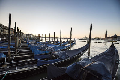 Boats moored in canal against clear sky