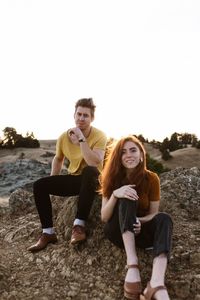 Portrait of young couple sitting on land