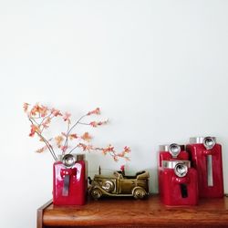 Close-up of red flowers on table against wall