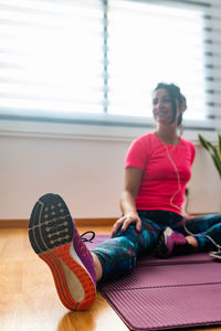 Full length of woman sitting on floor at home