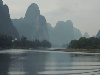 Scenic view of river and mountains against sky