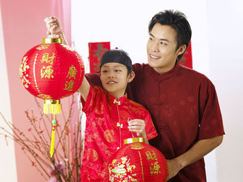 Boy with father holding lantern during festival