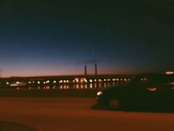 Illuminated bridge against sky at night