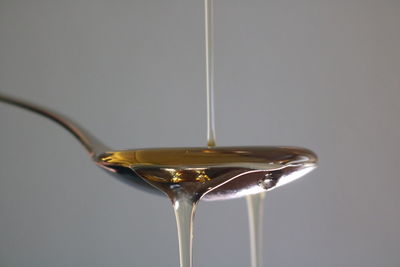 Close-up of wineglass on glass against white background