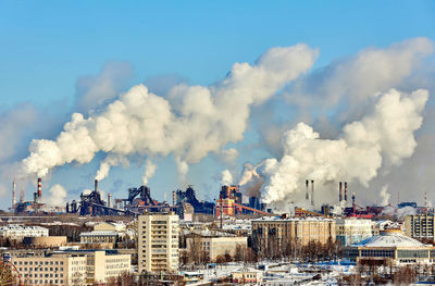 Smoke emitting from chimney against sky