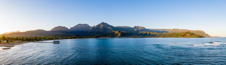 Aerial panoramic image at sunrise off the coast over hanalei bay and pier on kauai