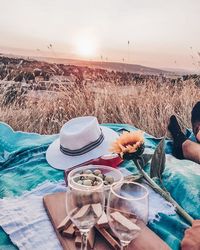 Lounge chairs by swimming pool on field against sky during sunset