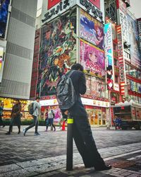 Rear view of woman on multi colored city against sky