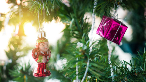 Close-up of gift box and figurine hanging on christmas tree