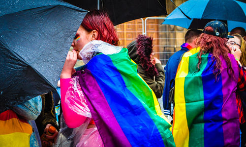 Full length of people in multi colored umbrella