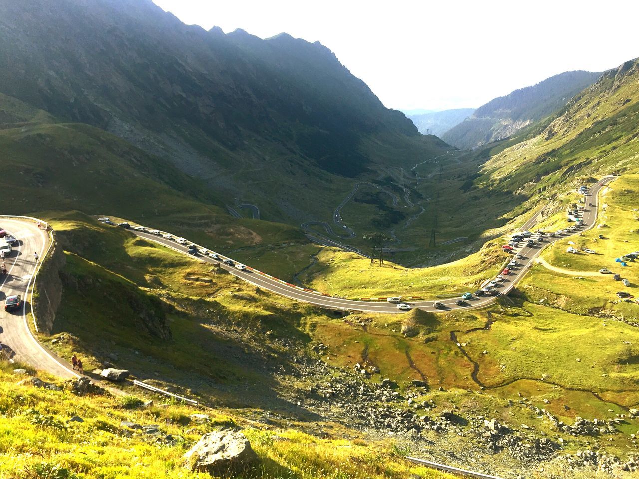 mountain, nature, mountain range, scenics, beauty in nature, tranquil scene, road, landscape, tranquility, winding road, non-urban scene, mountain road, outdoors, day, high angle view, sunlight, no people, curve, grass, sky