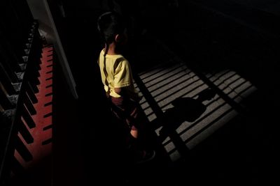Rear view of boy playing piano