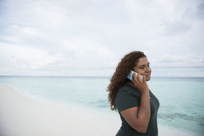 Woman talking via cell phone on beach