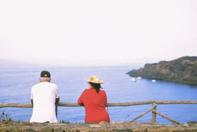 Rear view of couple standing against sea