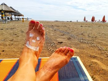 Low section of person relaxing on beach