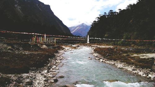 Scenic view of river and mountains against sky