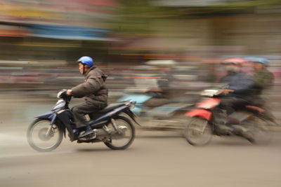 Blurred motion of man riding bicycle on road