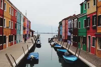 Boats moored in sea against buildings in city