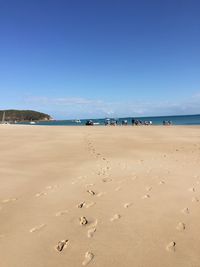 Scenic view of beach against clear blue sky