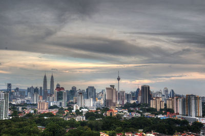 View of cityscape against cloudy sky