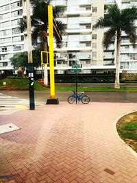 Bicycle parked on sidewalk by building in city