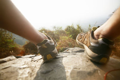 Low section of people on sand against sky