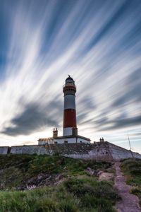 Low angle view of lighthouse amidst buildings against sky