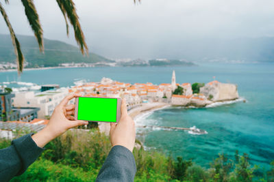 Midsection of woman photographing sea