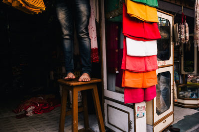 Low section of man standing on stool at market stall