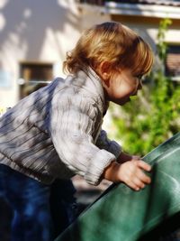 Side view of boy playing on slide at park