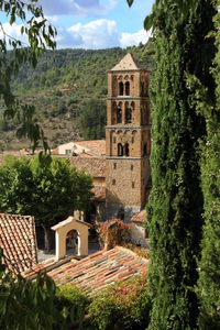 Houses by buildings in town against sky