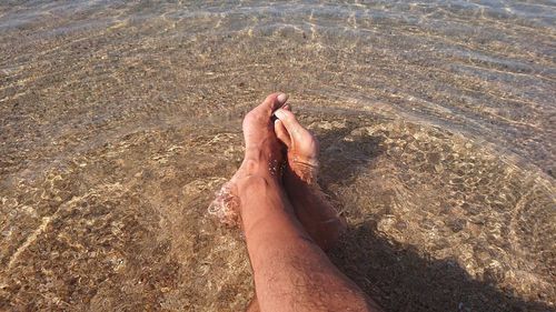 Low section of man legs on sand at beach