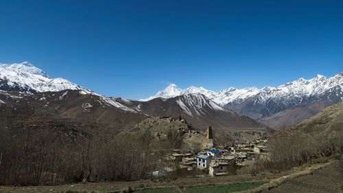 Scenic view of snowcapped mountains against clear blue sky